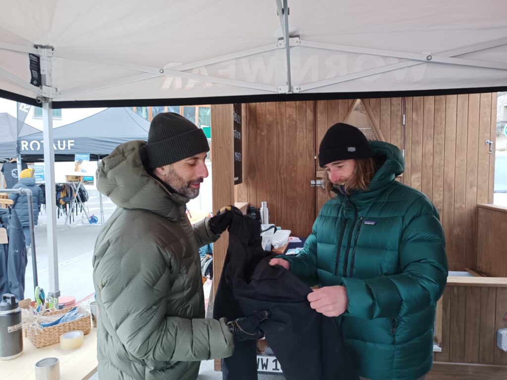 Lorenzo Bagordo und ein Mitarbeiter begutachten eine zu reparierende Skihose.